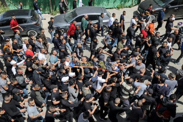 Mourners carry the body of a Palestinian killed earlier on Saturday during clashes with Israeli forces in Jenin in the occupied West Bank on April 9, 2022