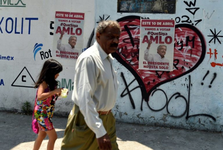 People walk past posters promoting a presidential recall referendum in Mexico City