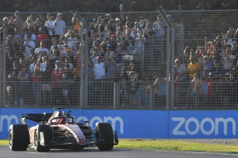 Ferrari's Monegasque driver Charles Leclerc acknowledges spectators during his victory lap after winning the 2022 Formula One Australian Grand Prix at the Albert Park Circuit in Melbourne on April 10, 2022.