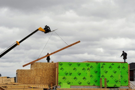 Construction workers are seen alongside a crane as they build homes in Calgary, Alberta, May 31, 2010.    