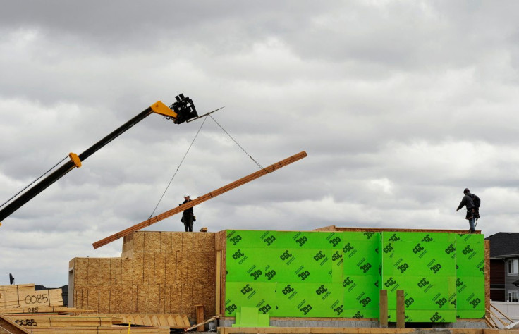 Construction workers are seen alongside a crane as they build homes in Calgary, Alberta, May 31, 2010.    