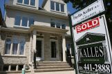 A real estate sign is seen on front of a house in Toronto June 19, 2009.     