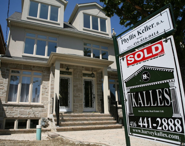 A real estate sign is seen on front of a house in Toronto June 19, 2009.     