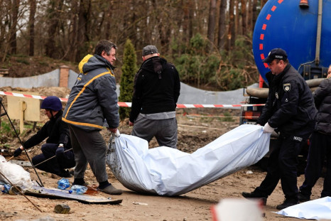 Police members carry the body of a civilian, who according to the head of the village was killed by Russian soldiers amid Russia's invasion of Ukraine, after they exhumed him along with another body from a well at the fuel station in Buzova, Kyiv region, 