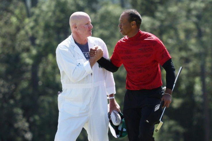 Mission accomplished: Tiger Woods and caddie Joe LaCava shake hands on the 18th green after their final round of the 86th Masters
