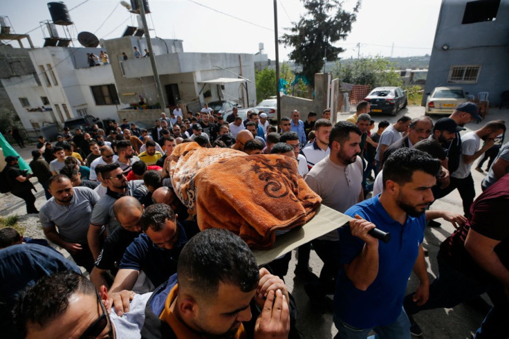 People carry the body of Palestinian woman Ghada Sabatin, who medics said was killed by Israeli forces, during her funeral in Husan in the Israeli-occupied West Bank April 10, 2022.