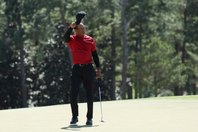 Tiger Woods tips his hat to the crowd on the 18th green after finishing the final round at the 86th Masters