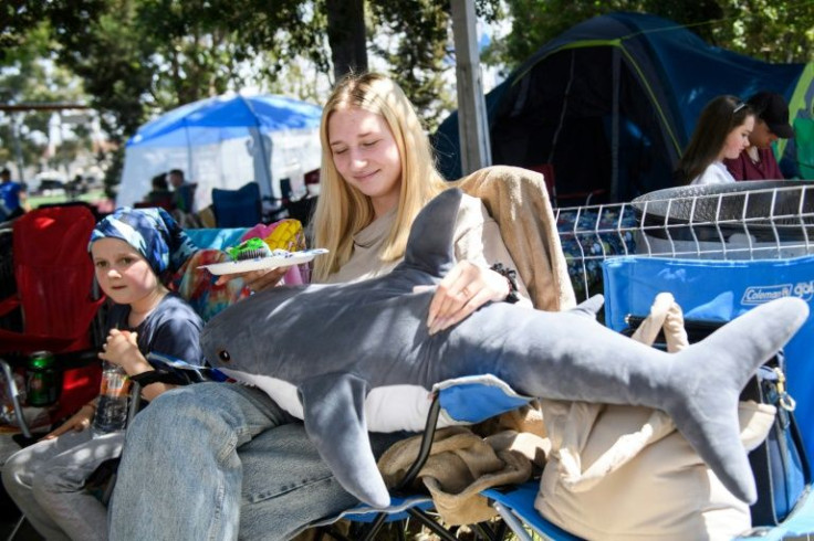 Anastasia Chorna, 15, holds a stuffed shark while waiting in a converted sports center in Tijuana, Mexico; she and her mother had fled the war in Ukraine, but her father had to remain behind