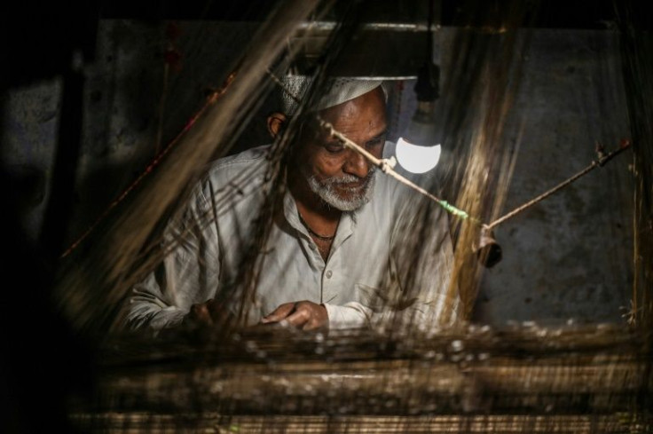 In a dim room near the banks of India's Ganges river, arms glide over a creaking loom as another silken fibre is guided into place with the rhythmic clack of a wooden beam