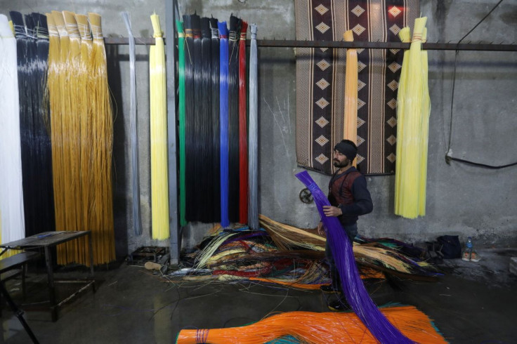 A worker arranges plastic strings used for mats production, outside a factory at the industrial zone of Syria's rebel-held city of Al-Bab, Syria March 8, 2022. Picture taken March 8, 2022.