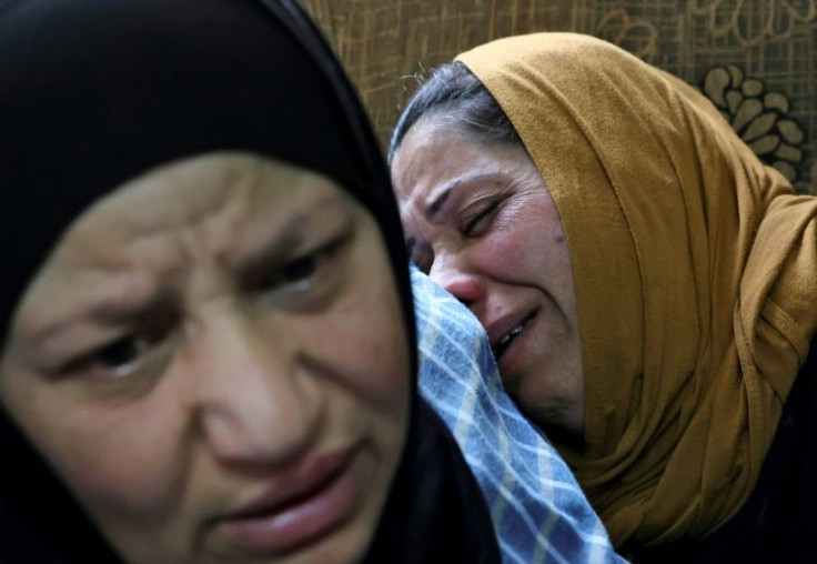 The mother of Palestinian Mohammed Ghnaim (R) is comforted during his funeral in al-Khader village near Bethlehem city in the occupied West Bank, on April 11, 2022, a day after the Israeli army shot him dead, saying he had thrown a Molotov cocktail