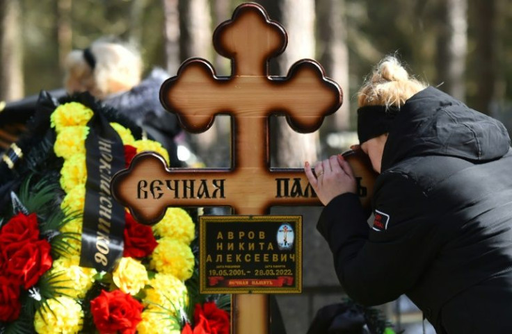 The young serviceman's mother grieves during his funeral at a church in Luga some 150kms south of Saint Petersburg