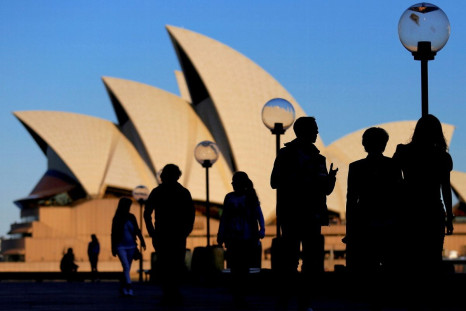 People are silhouetted against the Sydney Opera House at sunset in Australia, November 2, 2016. 