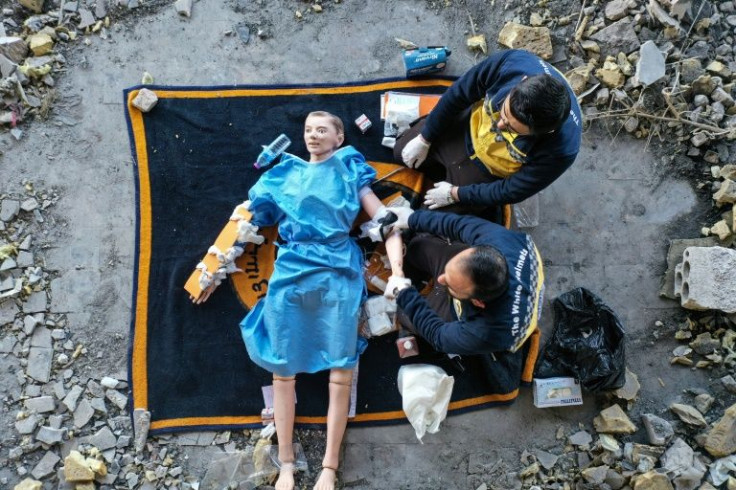 Members of the Syrian White Helmets use a dummy to demonstrate rescue skills in an instructive film intended for Ukrainians