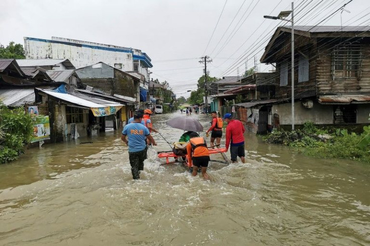 Philippine Coast Guard personnel evacuate a resident from a flooded area of Leyte province following tropical storm Megi