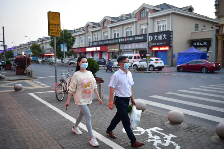 Residents walk on a street in Fengjing town of Jinshan district, as the city eases the lockdown in some areas amid the coronavirus disease (COVID-19) outbreak, in Shanghai, China April 11, 2022.  Picture taken April 11, 2022. cnsphoto via REUTERS  