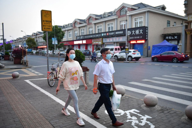 Residents walk on a street in Fengjing town of Jinshan district, as the city eases the lockdown in some areas amid the coronavirus disease (COVID-19) outbreak, in Shanghai, China April 11, 2022. Picture taken April 11, 2022. cnsphoto via REUTERS