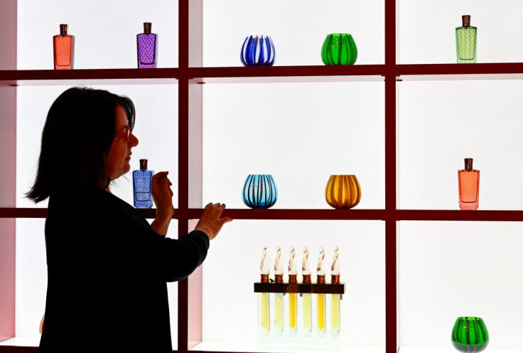 A woman is seen near vials of perfume and scented lanterns in Murano glass at The Merchant of Venice cosmetics shop in Milan, Italy March 30, 2022.