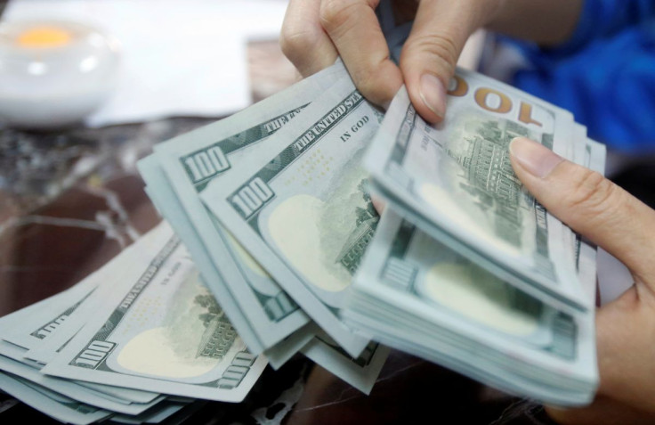 An employee of a bank counts US dollar notes at a branch in Hanoi, Vietnam May 16, 2016. 