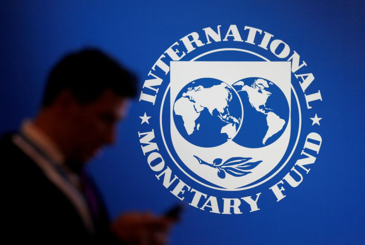 A participant stands near a logo of IMF at the International Monetary Fund - World Bank Annual Meeting 2018 in Nusa Dua, Bali, Indonesia, October 12, 2018. 