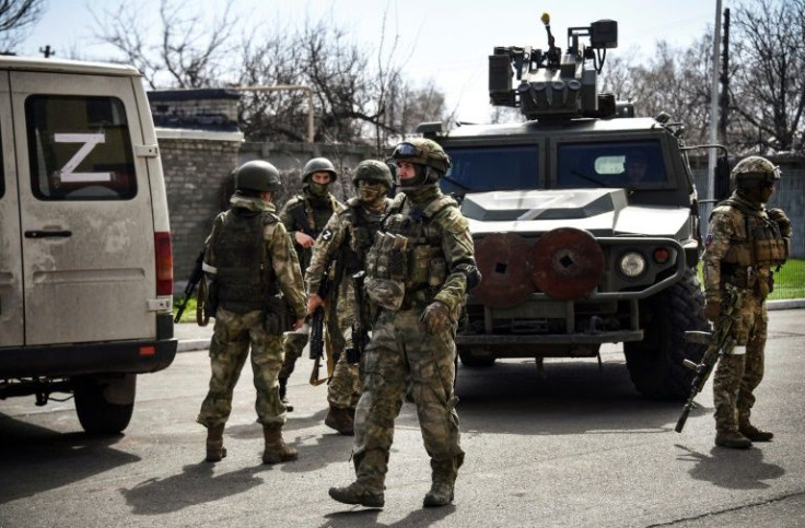 Even with no sign of resistance, Russian tanks and military vehicles patrol Volnovakha's streets as civilians walk around and cycle