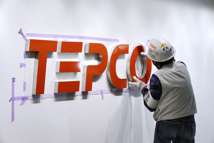 A worker puts up new logo of TEPCO Holdings and Tokyo Electric Power Company (TEPCO) Group on the wall ahead of the transition to a holding company system through a company split at the TEPCO headquarters in Tokyo, Japan,  March 31, 2016. 