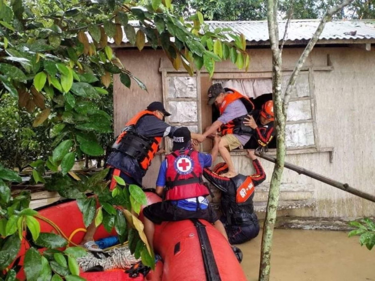 Rescue personnel assist a man onto a rescue boat, after the tropical storm Megi hit, in Capiz Province, Philippines April 12, 2022. Philippine Coast Guard/Handout via REUTERS