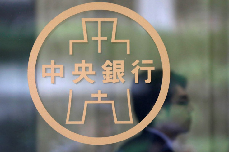 A staff member stands beside the Taiwanese Central Bank logo in Taipei, Taiwan February 26, 2018. 