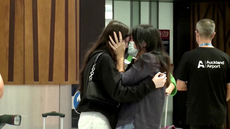 People hug in the arrivals area at the Auckland Airport, as Australians started arriving after the country opened its borders to travellers from its neighboring nation for the first time since mid-2021, in Auckland, New Zealand, April 13, 2022 in this sti