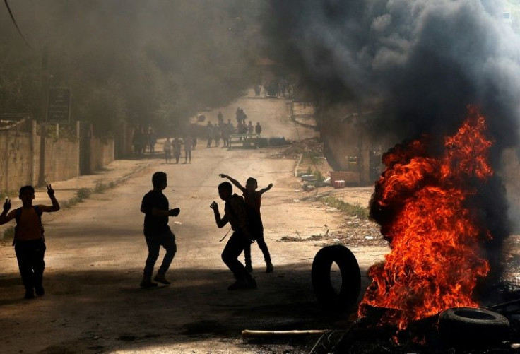 Palestinian children burn tyres following an Israeli army raid on the West Bank town of Jenin