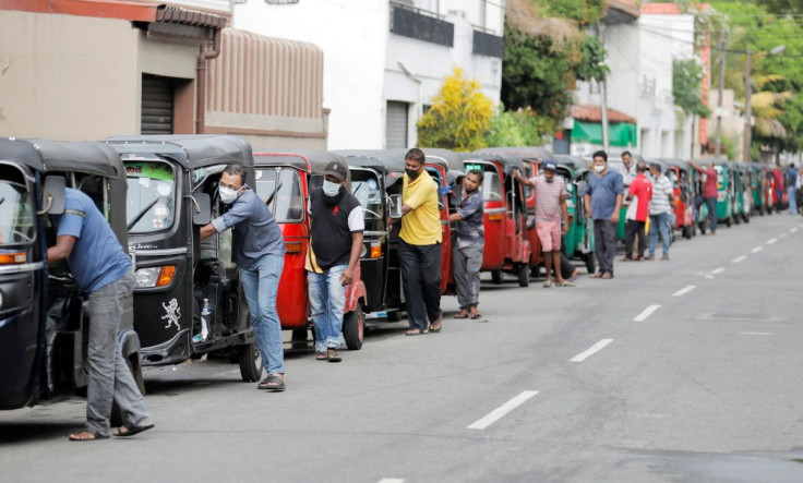 Drivers push their three-wheelers while waiting in a line to buy petrol at a Ceylon Ceypetco fuel station on a main road, amid the country's economic crisis in Colombo, Sri Lanka, April 12, 2022.