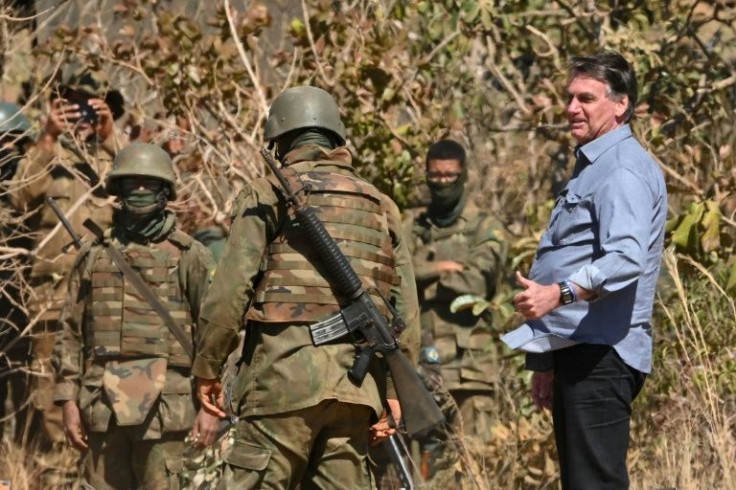 Brazilian President Jair Bolsonaro (R) speaks with soldiers during military exercises in 2021