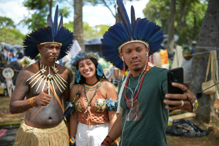 Digital indigenous activist Tukuma Pataxo, of the Pataxo tribe, makes a selfie with colleague Samela Awia (L), of the Satere Mawe Amazonian tribe