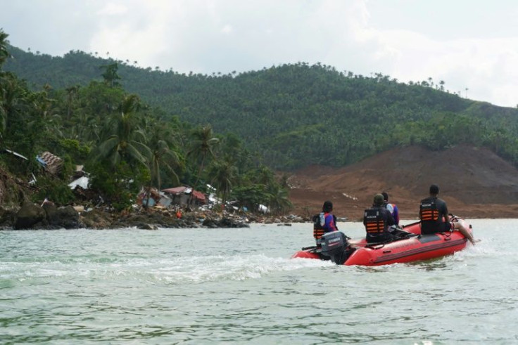 Rescue workers aboard an inflatable boat approach the landslide-struck coastal village of Pilar