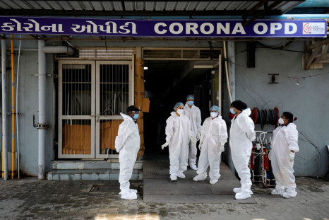 Healthcare workers wearing personal protective equipment (PPE) stand at the entrance of a coronavirus disease (COVID-19) hospital in Ahmedabad, India, January 7, 2022. 