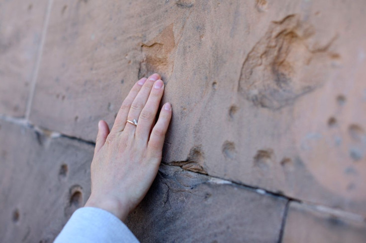 Viktoria Naumenko, a 39-year-old war historian from Kharkiv, Ukraine touches a hole caused by shrapnel from the Battle of Berlin in World War Two on a facade of the Humboldt-University Berlin School of Business and Economics, in Berlin, Germany March 28,