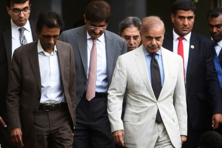Pakistan Prime Minister Shehbaz Sharif (white suit) leaving a meeting in Karachi the day after being sworn in
