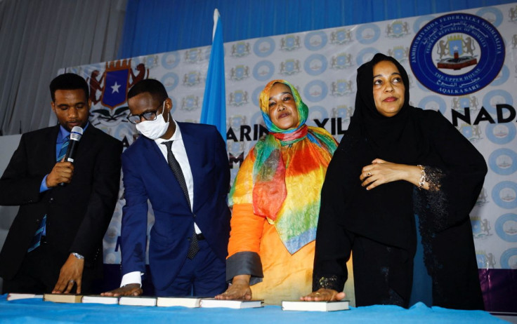 Somalia's newly elected lawmakers place their hands on copies of the Koran as they are sworn in to office at the Afisyoni election hall in Mogadishu, Somalia, April 14, 2022.