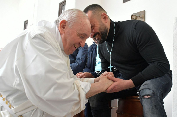 Pope Francis holds hands with an inmate as the Pope performs the "Washing of the Feet" of inmates at the Civitavecchia prison in Civitavecchia, Italy, April 14, 2022. Vatican Media/Handout via REUTERS