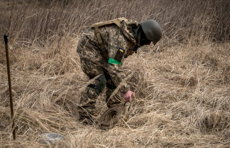 A member of a bomb disposal squad works in a mine field near Brovary, northeast of Kyiv