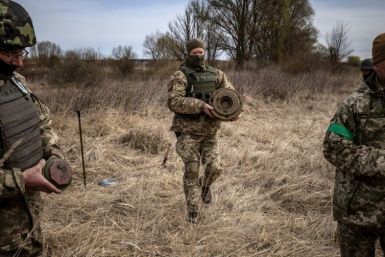 A team of soldiers are wandering around with sure-footed ease, clearing a minefield outside the Kyiv suburb of Brovary of explosives planted by retreating Russian forces