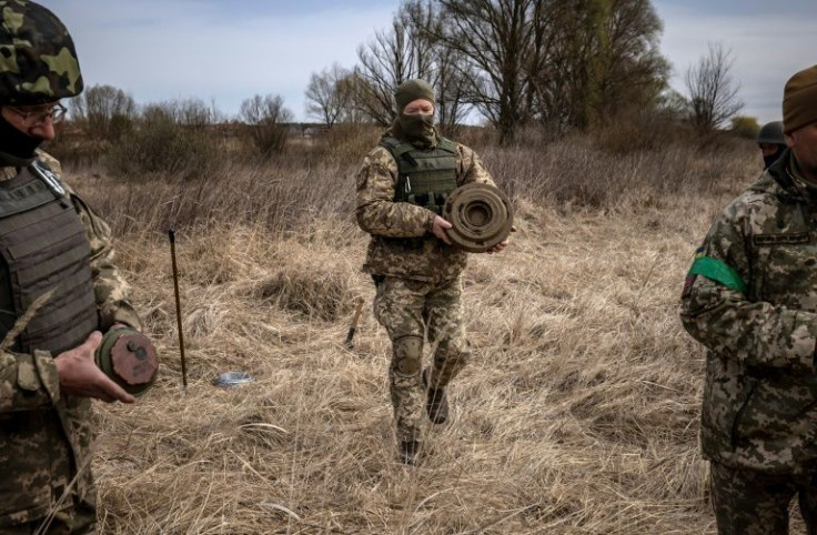 A team of soldiers are wandering around with sure-footed ease, clearing a minefield outside the Kyiv suburb of Brovary of explosives planted by retreating Russian forces