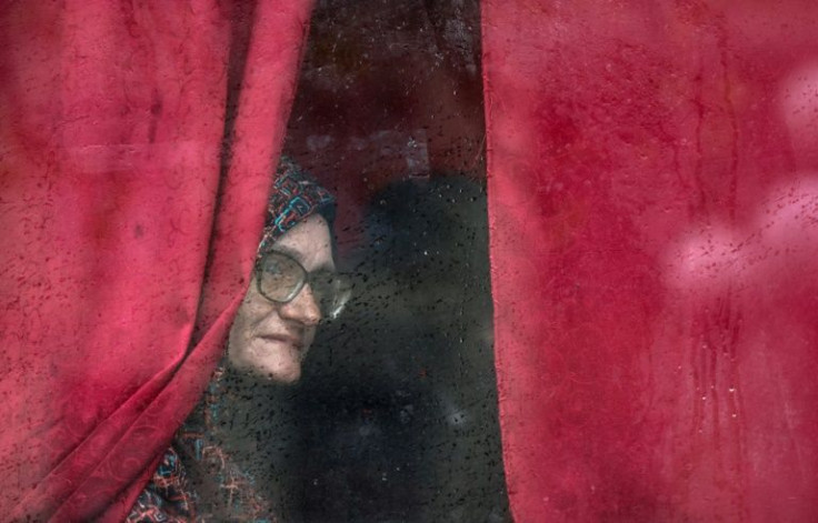 A woman looks out from a bus window as she leaves Severodonetsk, in eastern Ukraine's Donbas region, on April 13, 2022