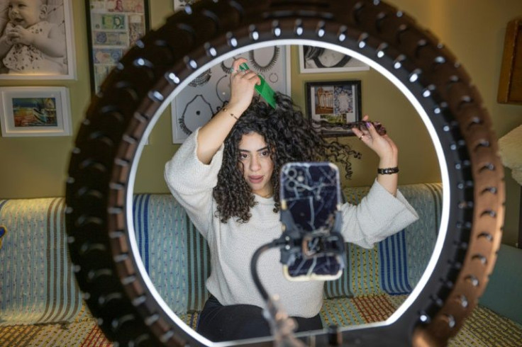 Mariam Ashraf, a teacher and "natural hair influencer", combs her hair during a livestream to her more than 90,000 followers