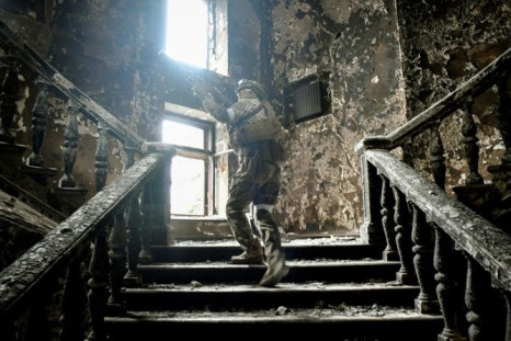 Russian soldiers patrol in the bombed Mariupol theatre during a media tour organised by Russia