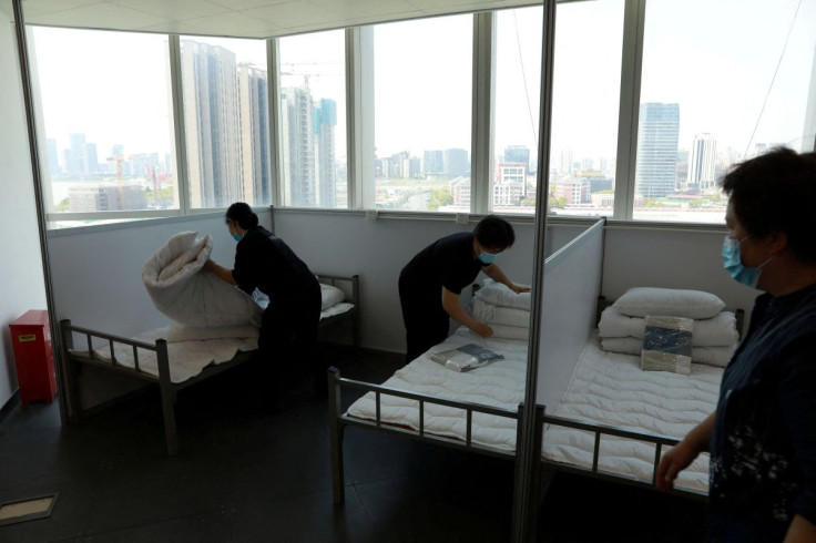 Workers make beds at a 17-storey office building to convert it into a makeshift hospital for the coronavirus disease (COVID-19), in Shanghai, China April 12, 2022. China Daily via REUTERS
