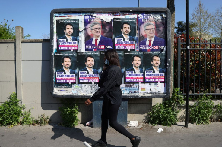 A young woman walks past an official campaign poster of Jean-Luc Melenchon, leader of the far-left opposition party La France Insoumise (France Unbowed - LFI) and L'Union populaire (popular union) candidate in the 2022 French presidential election, in