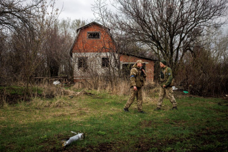 Ukrainian soldiers stand outside an abandoned Russian outpost, amid Russia's attack on Ukraine, in the village of Husarivka, in Kharkiv region, Ukraine, April 14, 2022. Picture taken April 14, 2022. 