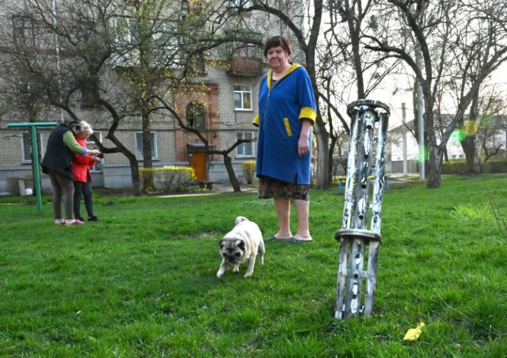 In Kharkiv, the charred remains of three rockets are visible -- two stabbed into grassland by apartment buildings and a third in a nearby bin