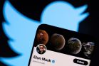 Elon Musk's twitter account is seen on a smartphone in front of the Twitter logo in this photo illustration taken, April 15, 2022. 